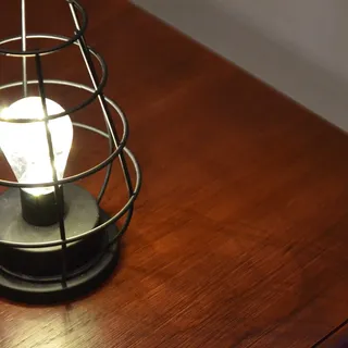 A cage lamp on a wooden table